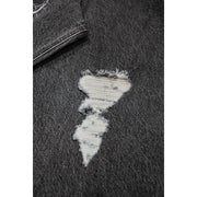 Close-up of dark gray denim fabric with a distressed hole revealing white threads