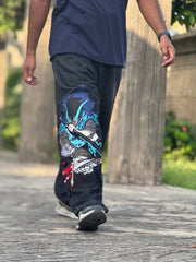 Person walking outdoors wearing black pants with vibrant anime character print and casual sneakers